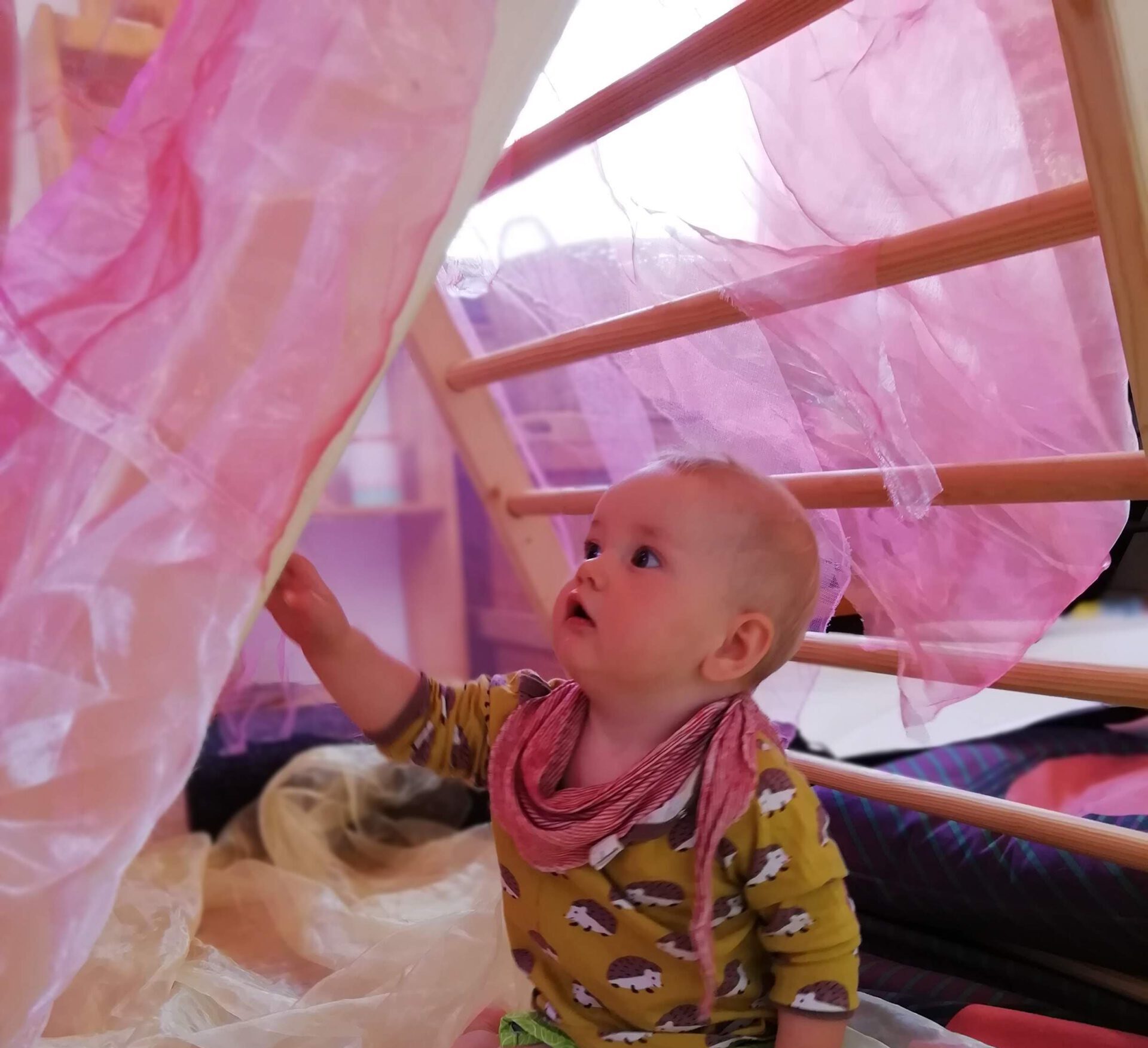 Kleinkind spielt in einem rosa Spielzelt